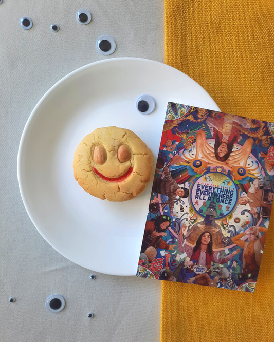 Smiley faced almond cookie with a poster from the film Everything Everywhere All At Once.